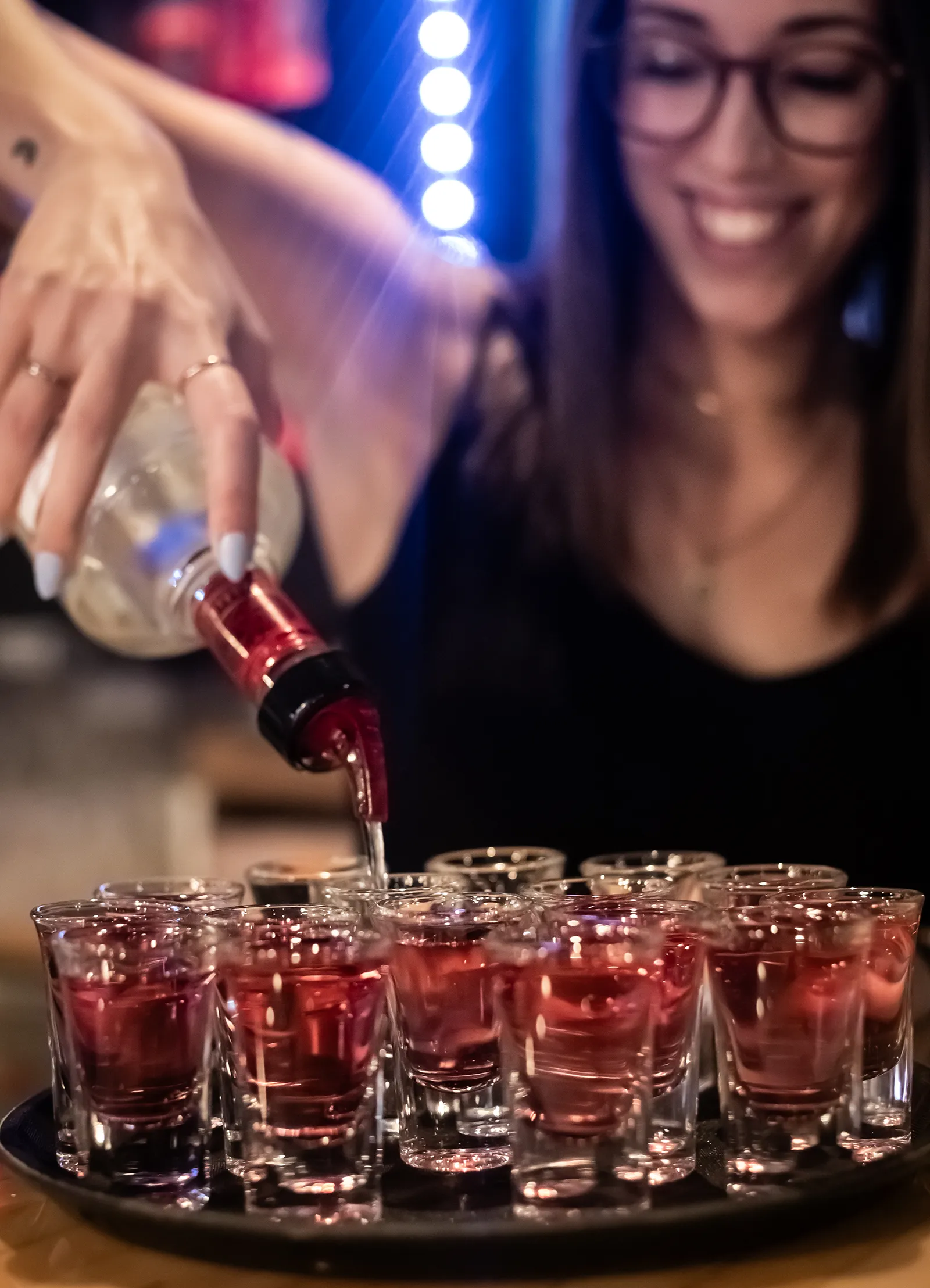 Serveuse préparant des shooters dans une ambiance festive à la Taverne Gordon
